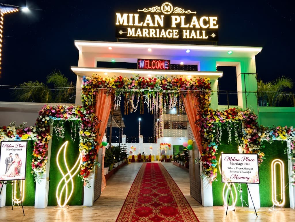 Milan Place Marriage Hall — grand floral entrance with red carpet and neon welcome sign